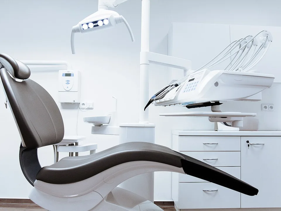 Modern eingerichtetes Behandlungszimmer mit Behandlungsstuhl und Lampe